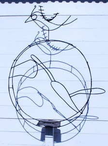 ציפור על גלגל שיח צבר. ברזל על קיר עץ צבוע לבן. אלמנט עם צל.